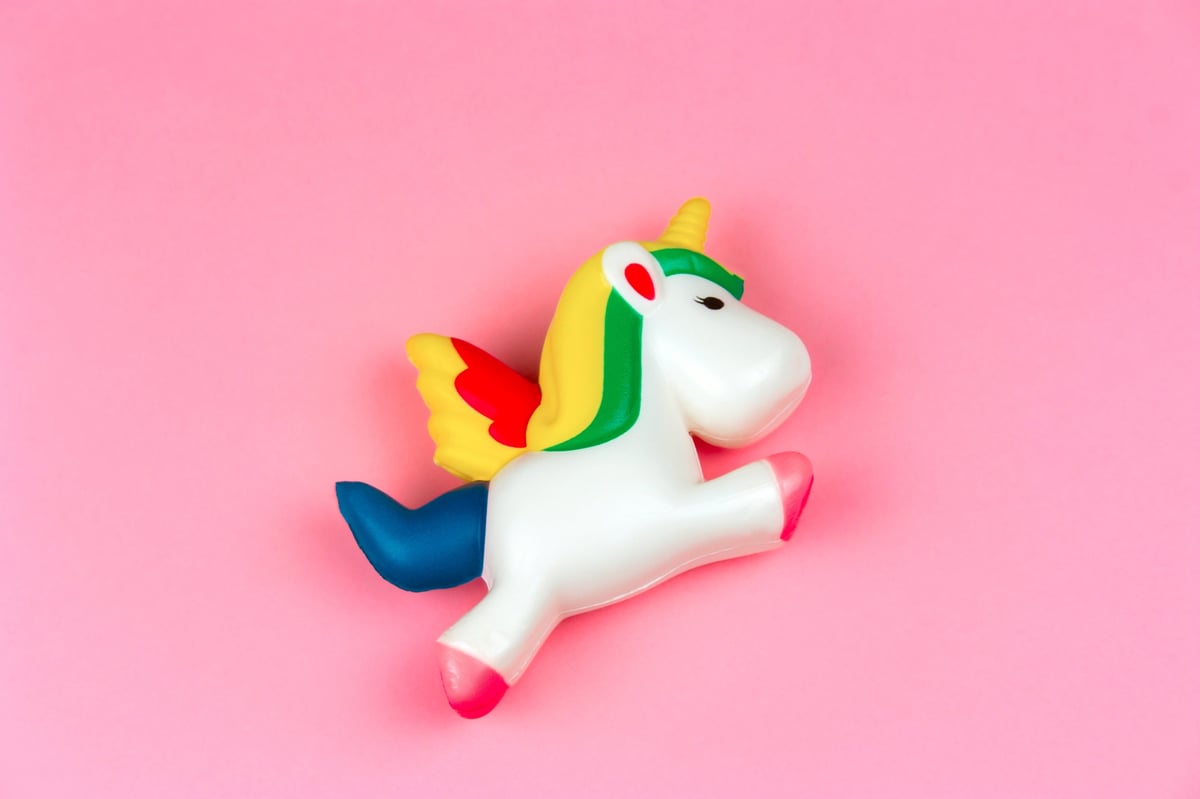 A squishy unicorn toy on a pastel pink background